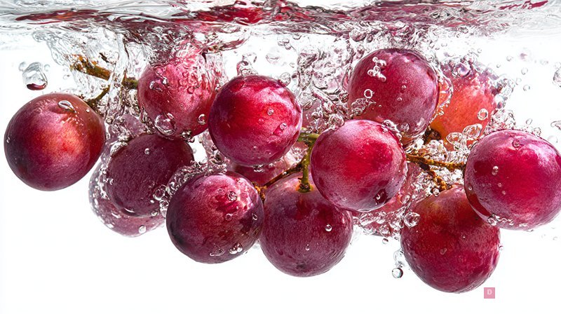 Fresh Red Grapes Splashing in Clear Water